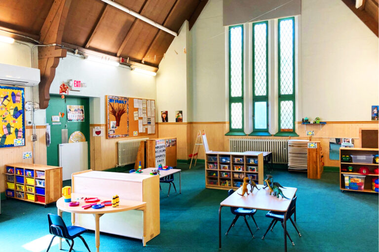 interior of preschool with various shelves tables and chairs