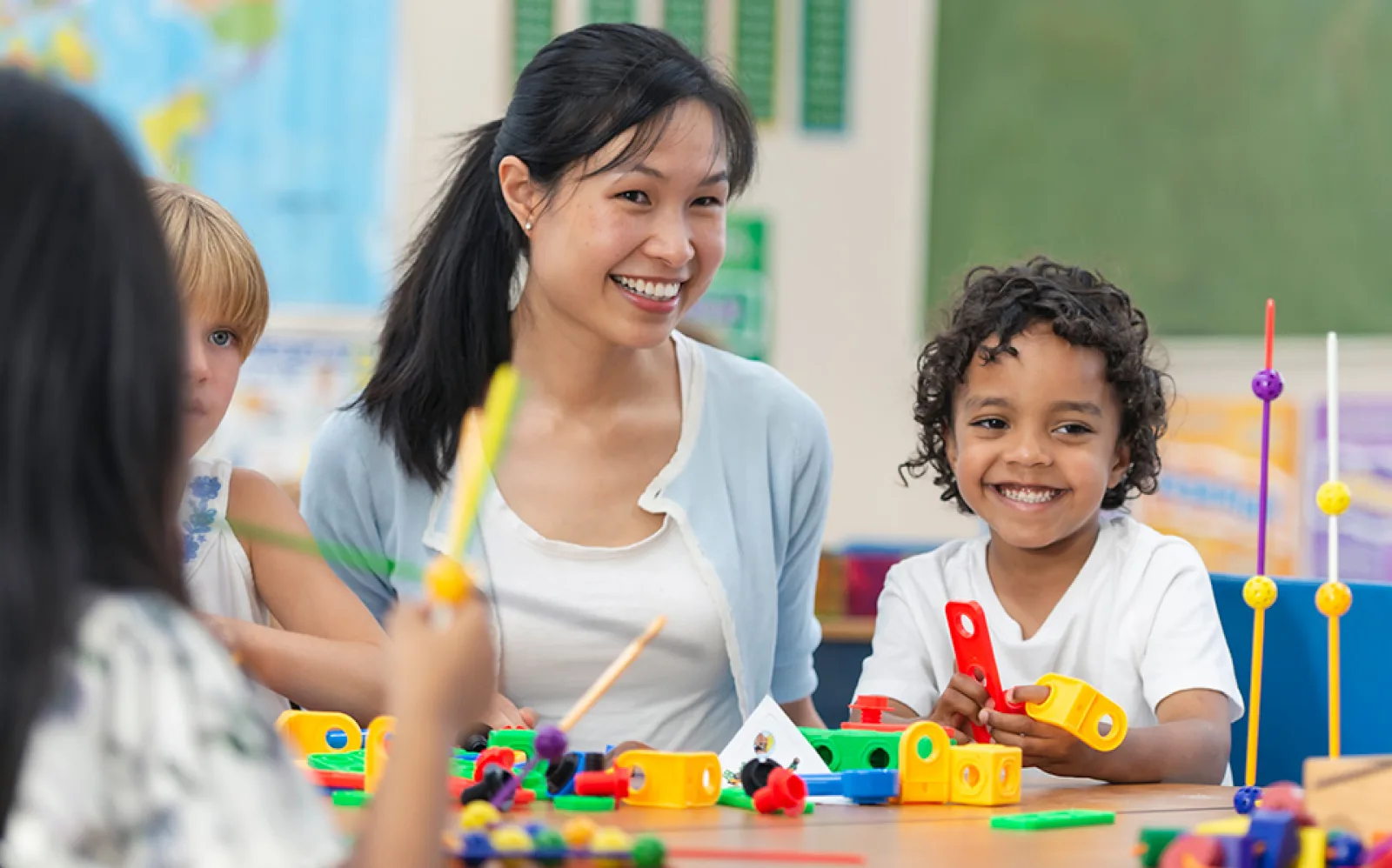 children playing at a table with an adult