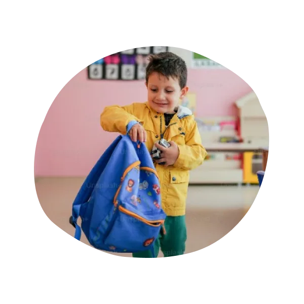 A child holding a backpack