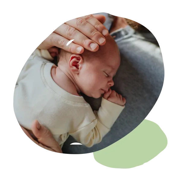 Adult hands holding a sleeping baby